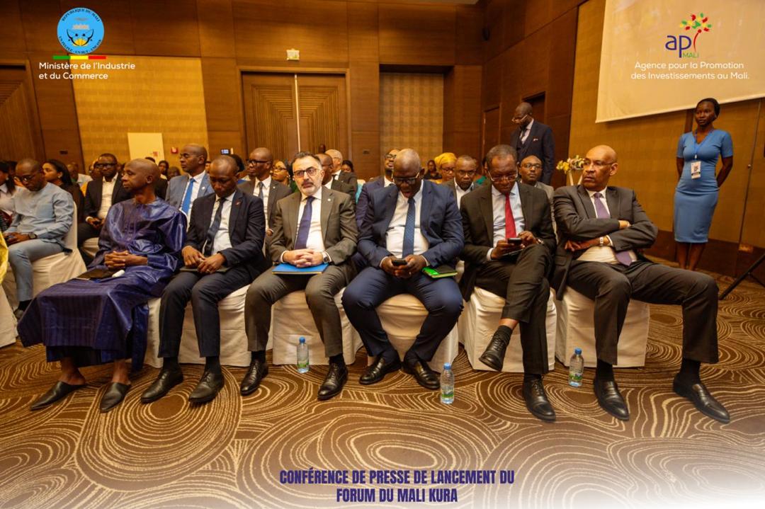 Launch press conference of the Mali Kura Forum: in the front row, officials and investors in suits and a blue grand boubou sit side by side, a hostess in a blue dress stands on the right, with the logos of the Ministry of Industry and Commerce and of API-Mali at the top of the image.